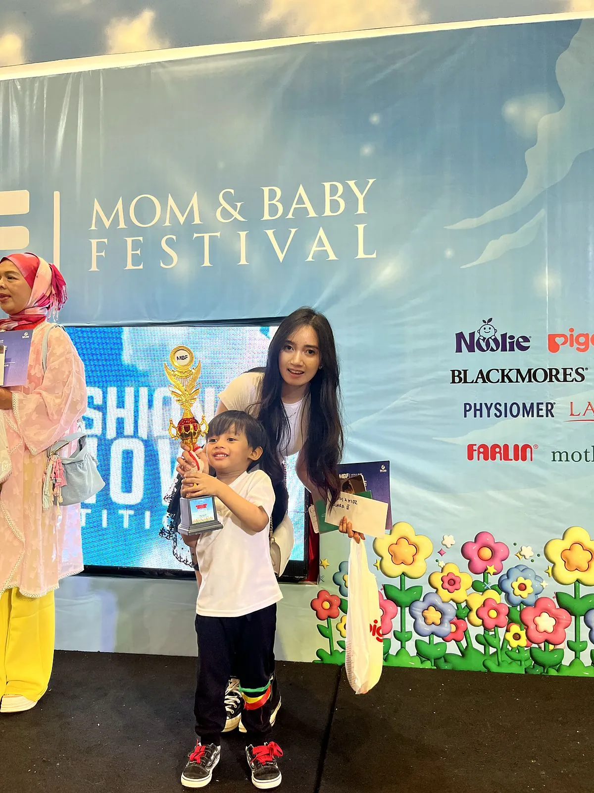 Champion with trophy – Mom & Baby Festival